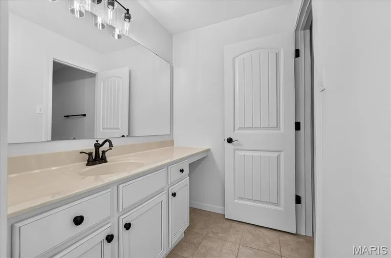 Bathroom vanity featuring a single basin, bronze-finish faucet, and light-toned countertop — 302 Oak Stand Court, Chesterfield, MO 63005