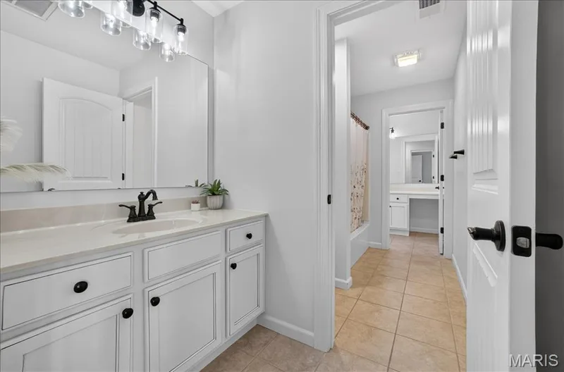 White vanity with a light-colored countertop and a dark-finished faucet — 302 Oak Stand Court, Chesterfield, MO 63005