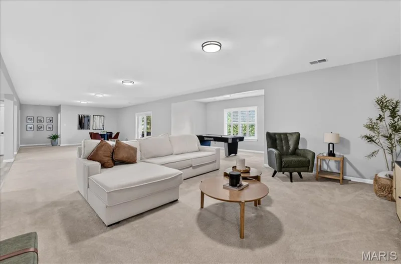 Expansive open-concept living area featuring light gray walls, neutral carpeting, and recessed lighting — 302 Oak Stand Court, Chesterfield, MO 63005