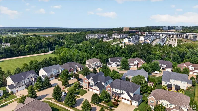 Aerial perspective showcasing a residential neighborhood with varied architectural styles, mature trees, and manicured lawns — 302 Oak Stand Court, Chesterfield, MO 63005