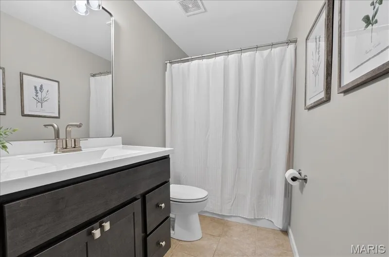 Bathroom featuring a dark wood-finish vanity with a white countertop and integrated sink — 302 Oak Stand Court, Chesterfield, MO 63005