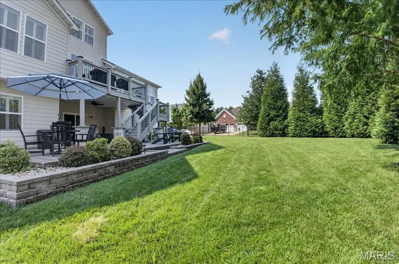 Expansive lawn with mature trees and a multi-level outdoor living space — 302 Oak Stand Court, Chesterfield, MO 63005