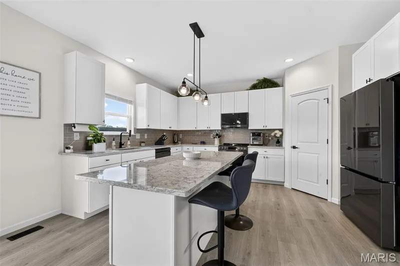 Soak in this spacious and exquisitely designed kitchen! Nice and cozy to enjoy a quiet cup of coffee in the morning. Never miss a moment during entertaining with the open concept between the kitchen and living room! — 403 Yellow Rose Court, Wentzville, MO 63385