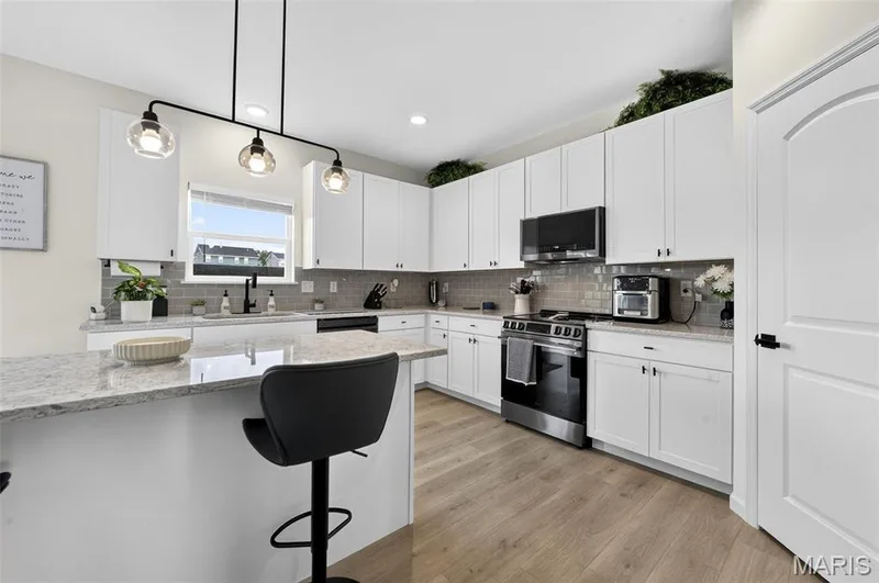 Soak in this spacious and exquisitely designed kitchen! Nice and cozy to enjoy a quiet cup of coffee in the morning. Never miss a moment during entertaining with the open concept between the kitchen and living room! — 403 Yellow Rose Court, Wentzville, MO 63385