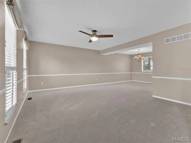 A view from the foyer looking toward the living room, with the dining room in the background.  Brand new carpet!! — 34 Shadow Creek Drive, St Peters, MO 63376