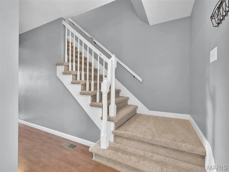 Spacious foyer with coat closet and steps offset to the right as you come inside.  Yes, that is brand new carpet! — 34 Shadow Creek Drive, St Peters, MO 63376