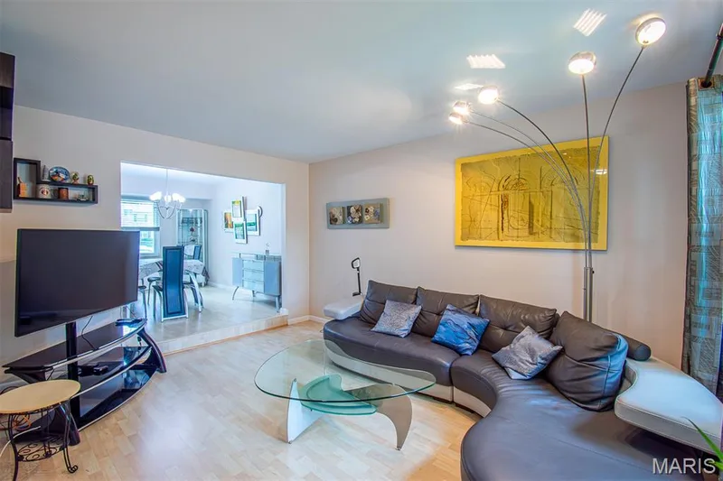 LIVING ROOM – Opens to Dining Room. Open-concept living space with light wood-finish flooring, a bright window. — 13261 COCHERO Drive, Chesterfield, MO 63141
