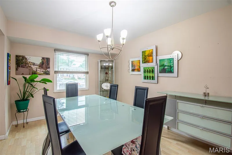 DINING ROOM – Opens to Living Room & Kitchen. Illuminated dining area featuring wood-finish flooring, a contemporary chandelier, and a window with horizontal blinds — 13261 COCHERO Drive, Chesterfield, MO 63141