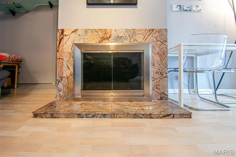 FAMILY ROOM - Fireplace featuring a natural stone surround and hearth, stainless steel trim, and glass doors — 13261 COCHERO Drive, Chesterfield, MO 63141