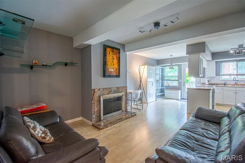 FAMILY ROOM –  With Fireplace - Opens to Kitchen with Breakfast Area & exit to the fenced backyard. Bright living area featuring light wood-finish flooring, light gray walls, and white ceiling beams — 13261 COCHERO Drive, Chesterfield, MO 63141
