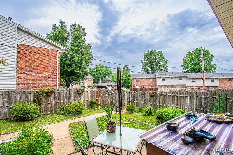 BACKYARD - Private fenced backyard featuring a concrete patio, a winding concrete path, and mature landscaping — 13261 COCHERO Drive, Chesterfield, MO 63141