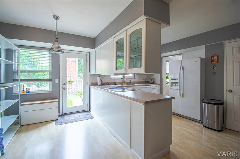 KITCHEN & BREAKFAST AREA  - Bright kitchen featuring wood-finish flooring, white cabinetry, and a glass-paneled door leading to the exterior — 13261 COCHERO Drive, Chesterfield, MO 63141