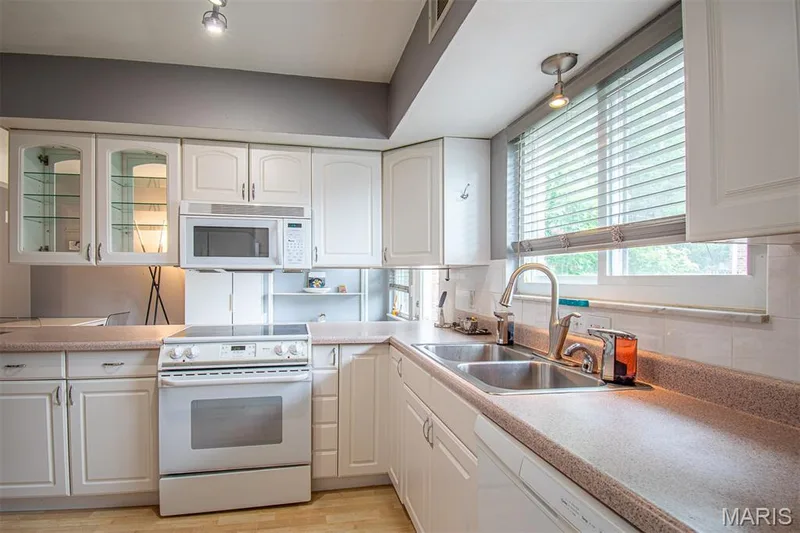 KITCHEN - Kitchen featuring white cabinetry, a built-in microwave, an electric range, a double basin sink, and a window with blinds — 13261 COCHERO Drive, Chesterfield, MO 63141