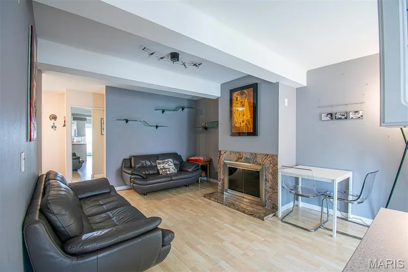 FAMILY ROOM –  With Fireplace - Opens to Kitchen with Breakfast Area & exit to the fenced backyard. Bright living area featuring light wood-finish flooring, light gray walls, and white ceiling beams — 13261 COCHERO Drive, Chesterfield, MO 63141