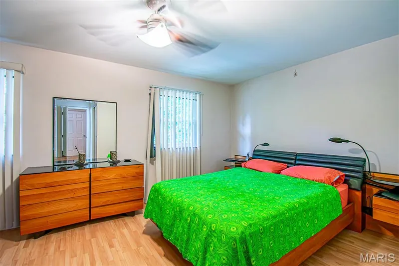PRIMARY BEDROOM – With Walk-in & Additional Closet, and Ensuite Bathroom with Shower. Bedroom with wood-finish flooring, two windows, and a ceiling fan with integrated lighting — 13261 COCHERO Drive, Chesterfield, MO 63141