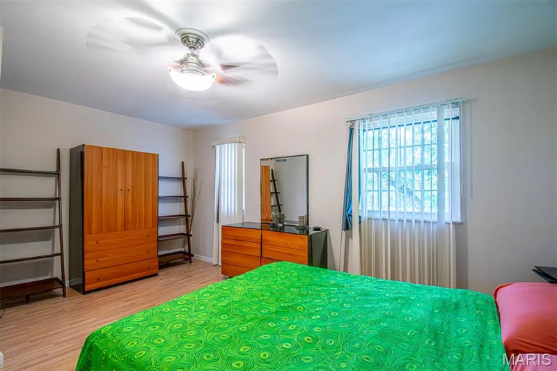 PRIMARY BEDROOM – With Walk-in & Additional Closet, and Ensuite Bathroom with Shower. Room featuring light wood-finish flooring, a ceiling fan with integrated lighting, and multiple windows with vertical blinds — 13261 COCHERO Drive, Chesterfield, MO 63141