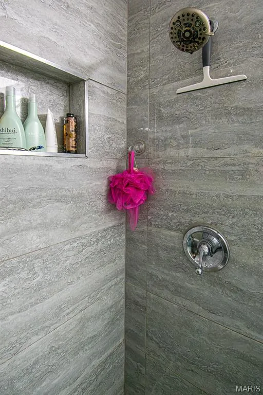 PRIMARY BATHROOM – Beautifully Remodeled - Shower enclosure featuring large format stone-look tile walls, a built-in shower niche with metallic trim, and a chrome shower control valve — 13261 COCHERO Drive, Chesterfield, MO 63141