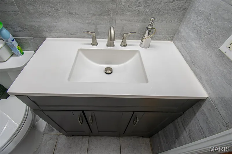 PRIMARY BATHROOM – Beautifully Remodeled & featuring a glass-enclosed shower with tile surround, a built-in shower niche, a dark gray vanity with an integrated sink, a brushed nickel faucet, and a wall-mounted medicine cabinet with mirrored doors — 13261 COCHERO Drive, Chesterfield, MO 63141