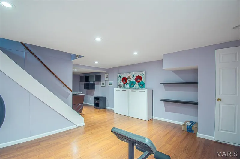 LOWER-LEVEL REC/R # 1 - featuring recessed lighting, wood-finish flooring, a built-in staircase with wood handrail, and a paneled interior door — 13261 COCHERO Drive, Chesterfield, MO 63141