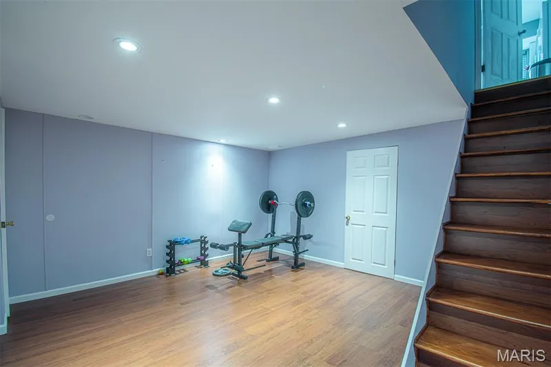LOWER-LEVEL REC/R # 1 - featuring wood-finish flooring, recessed lighting, and a white paneled door — 13261 COCHERO Drive, Chesterfield, MO 63141