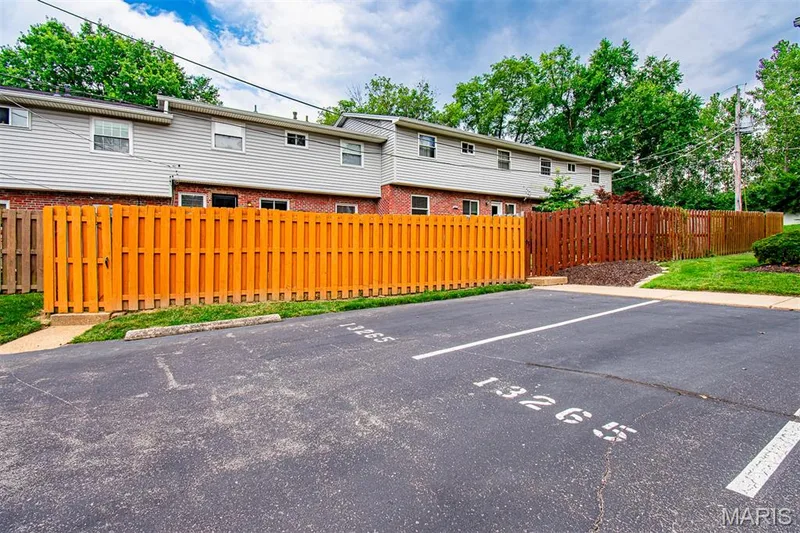ADDITIONAL PARKING ON BACK - Townhome exterior featuring gray siding and brick facade — 13261 COCHERO Drive, Chesterfield, MO 63141