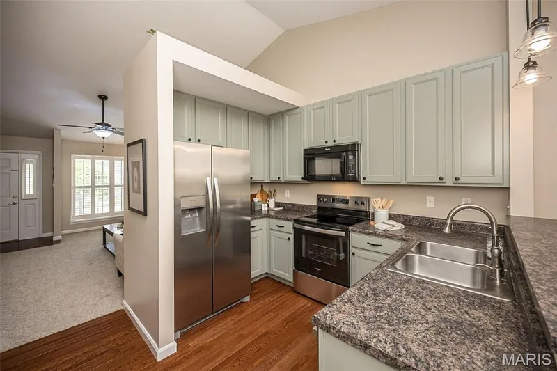 Kitchen featuring 42" cabinets, hardwood floors and (mostly) stainless steel appliances. — 249 Belmonte Circle, O'Fallon, MO 63368