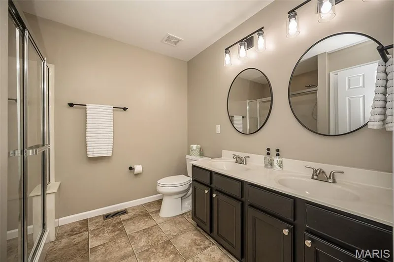 Primary bathroom with a double vanity and a large shower as well as comfort height toilets. — 249 Belmonte Circle, O'Fallon, MO 63368