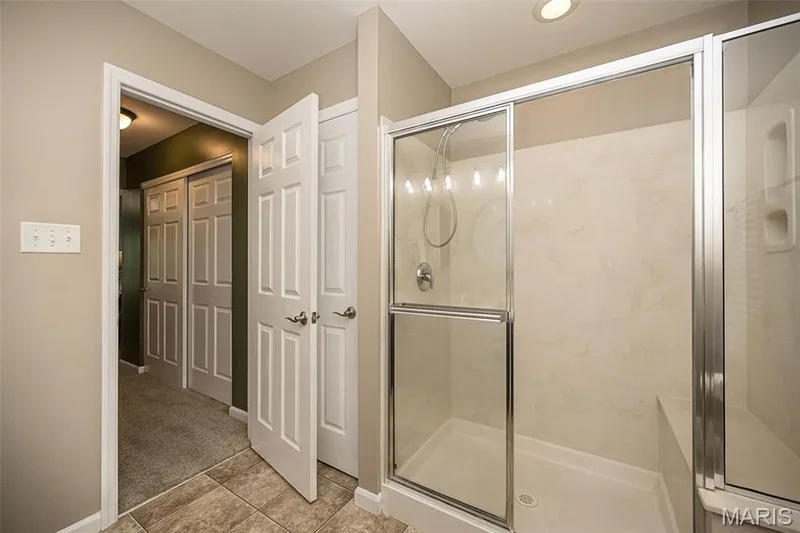 The shower in the primary bathroom has a nice seat and the bathroom also has a good sized linen closet. — 249 Belmonte Circle, O'Fallon, MO 63368