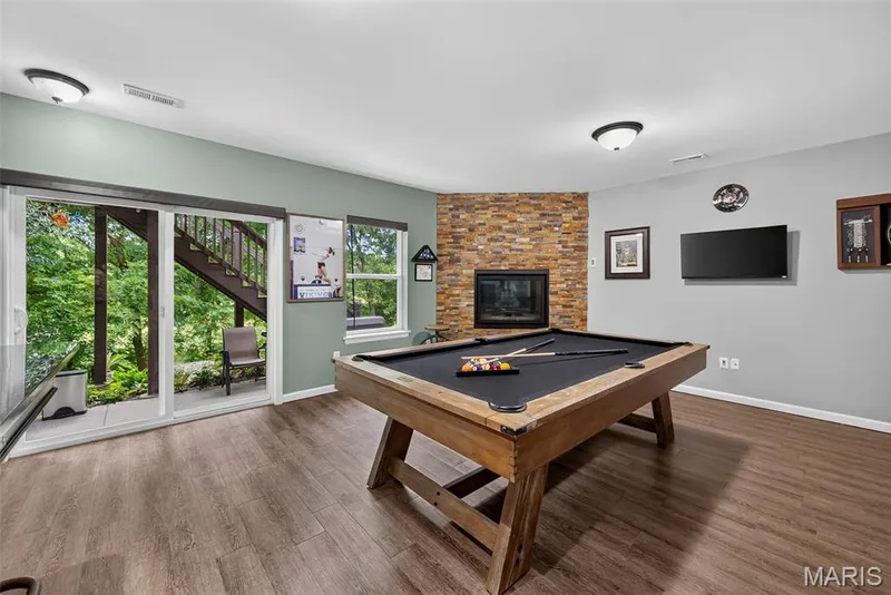 Recreation Room in the Finished Lower Level with Gas Fireplace and Sliding Door to the Patio — 2322 Wills Hollow Drive, St Peters, MO 63376
