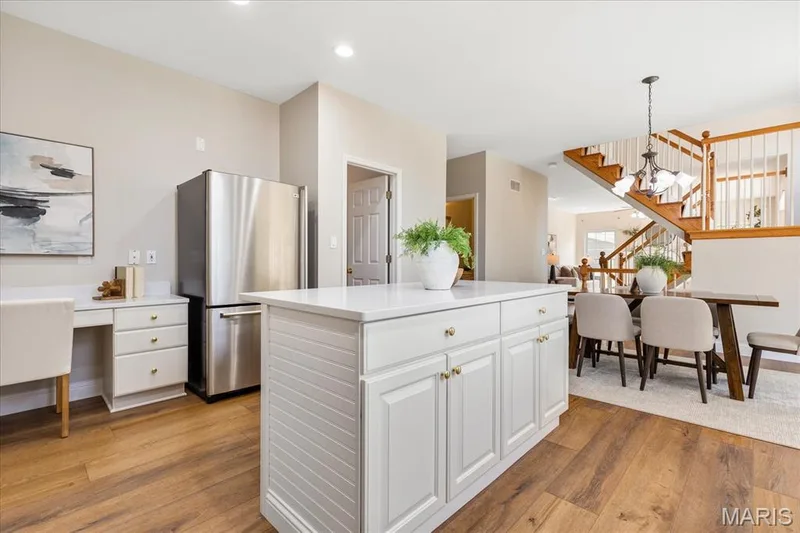 Functional kitchen layout complete with a built-in workstation, ample cabinet storage, and views toward the breakfast room and staircase. — 354 Buckington Street, St Peters, MO 63376