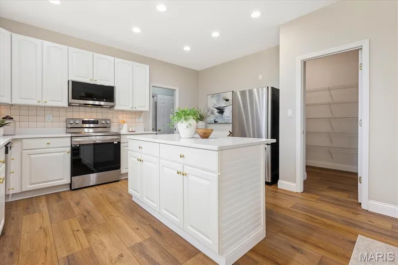 Ample cabinetry, brand-new quartz counters, and an oversized walk-in pantry make meal prep and storage a breeze. — 354 Buckington Street, St Peters, MO 63376