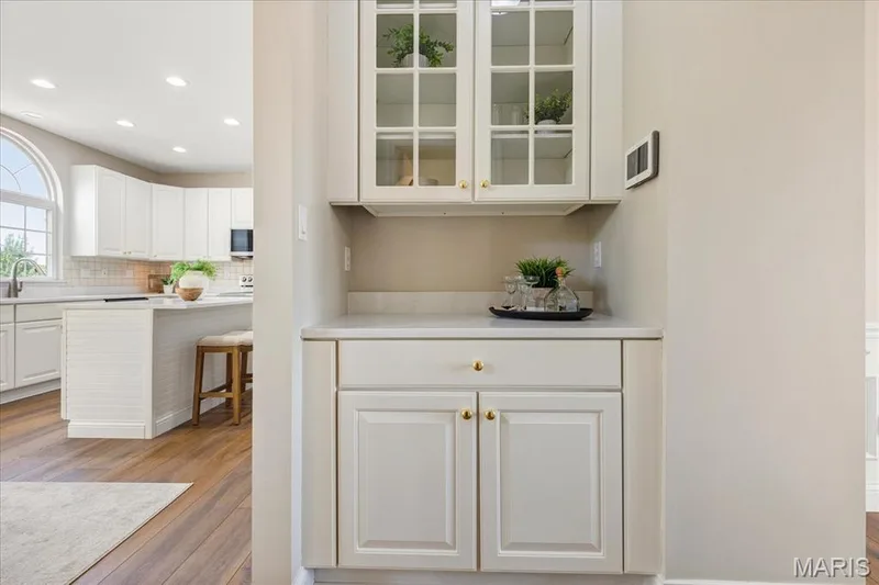 Built-in butler’s pantry with glass-display upper cabinets and counter space situated conveniently between kitchen and dining areas. — 354 Buckington Street, St Peters, MO 63376