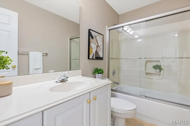 The third, full upper bathroom equipped with a large white vanity and a sliding glass door tub/shower combination. — 354 Buckington Street, St Peters, MO 63376