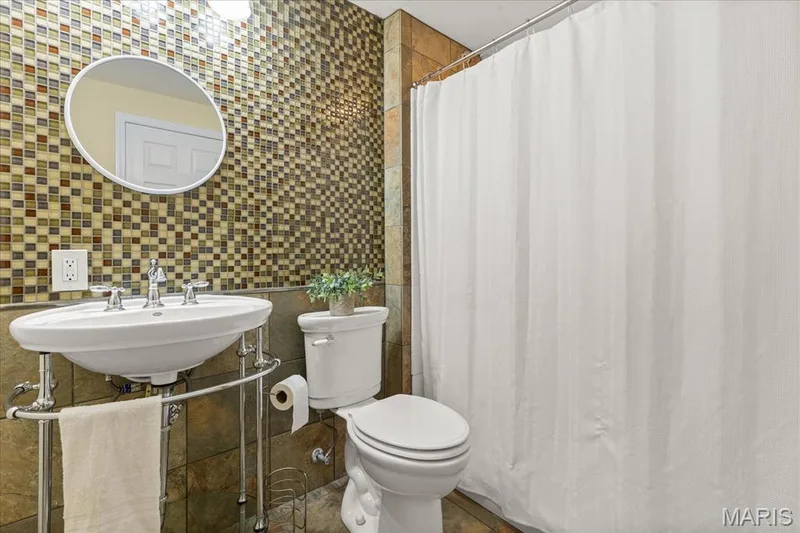 Beautiful mosaic tile and natural stone finishes create a spa-like full bath convenience in the lower level. — 354 Buckington Street, St Peters, MO 63376
