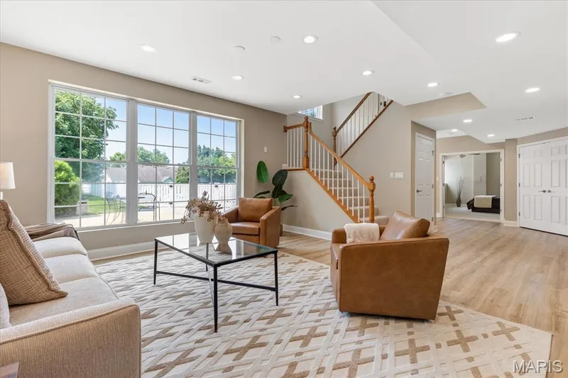 Natural light streams into the lower level living room, offering a bright and cheerful vantage point over your private backyard oasis. — 354 Buckington Street, St Peters, MO 63376