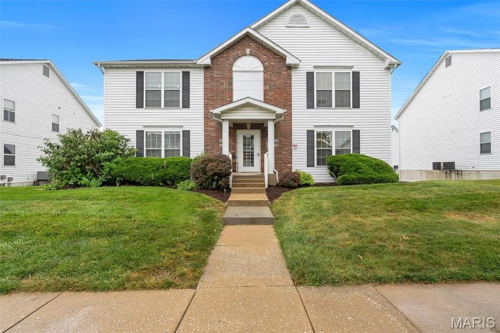 Two-story residence featuring a brick facade accent, white siding, and a covered entry — 640 Homerun Drive #37N, O'Fallon, MO 63366