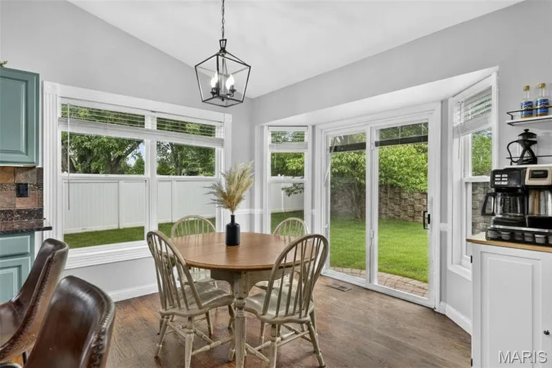 Vaulted ceiling, hard-surface flooring, bay window, sliding glass door, and geometric pendant lighting — 708 Woodland Ridge Drive, St Peters, MO 63376