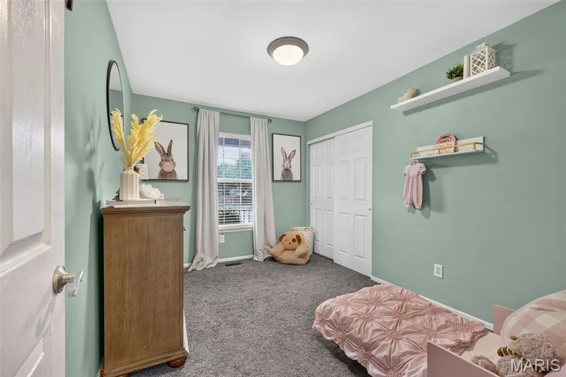 Carpeted flooring, window with blinds, bi-fold closet doors, ceiling-mounted light fixture, and wall-mounted shelving — 708 Woodland Ridge Drive, St Peters, MO 63376