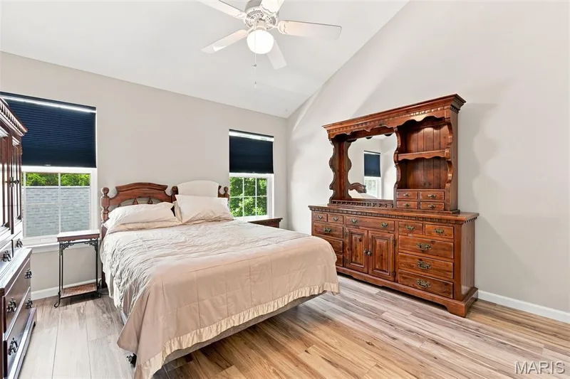 Vaulted ceiling with a ceiling fan, dual windows, wood-finish flooring, and light-toned walls — 16561 Carriage View Court, Wildwood, MO 63040