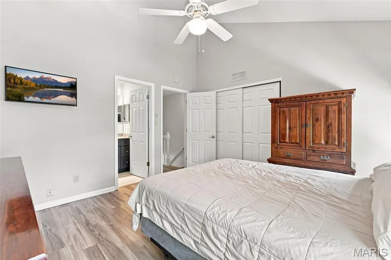 Vaulted ceiling with a ceiling fan, wood-finish flooring, and white sliding closet doors — 16561 Carriage View Court, Wildwood, MO 63040