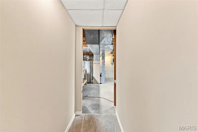 Hallway with suspended ceiling tiles and carpet flooring — 16561 Carriage View Court, Wildwood, MO 63040