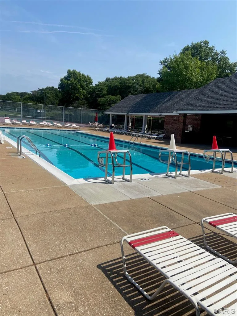 Lap pool with lane markers, concrete decking, and a covered poolside structure — 16561 Carriage View Court, Wildwood, MO 63040