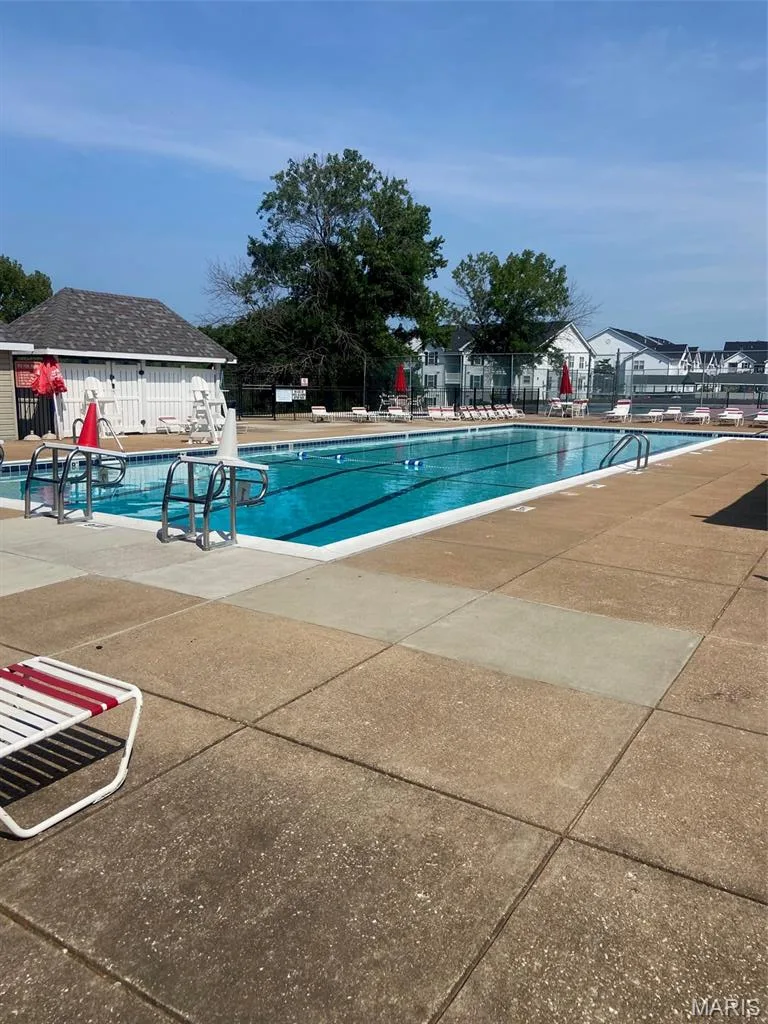 Olympic-sized swimming pool with designated lap lanes and deep-water diving area, surrounded by expansive concrete decking — 16561 Carriage View Court, Wildwood, MO 63040