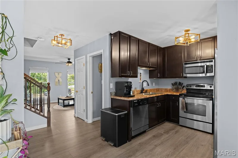 Kitchen featuring dark wood cabinetry, stainless steel appliances, and a brown countertop — 349 Shady Rock Lane, O'Fallon, MO 63368