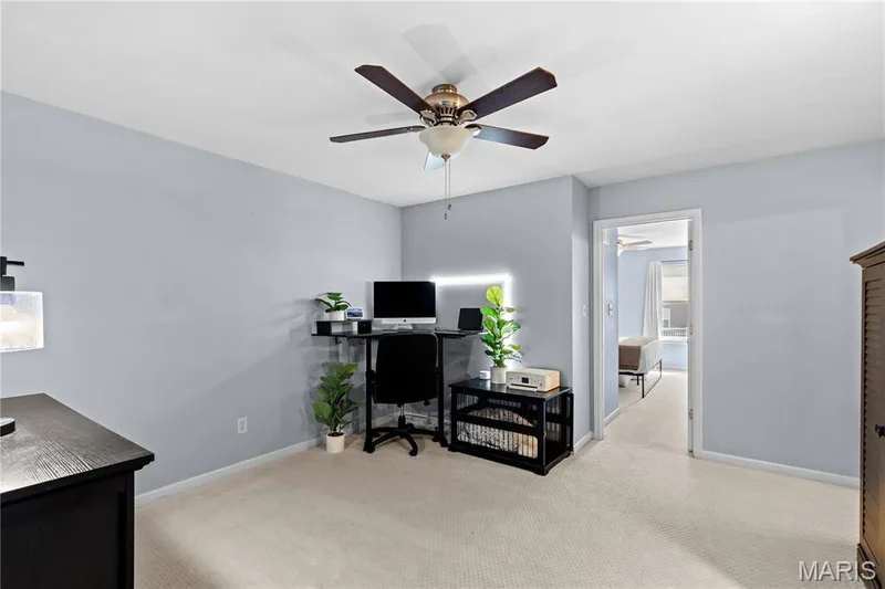 Room featuring light carpeting, a ceiling fan with integrated lighting, and a doorway leading to an additional space — 349 Shady Rock Lane, O'Fallon, MO 63368