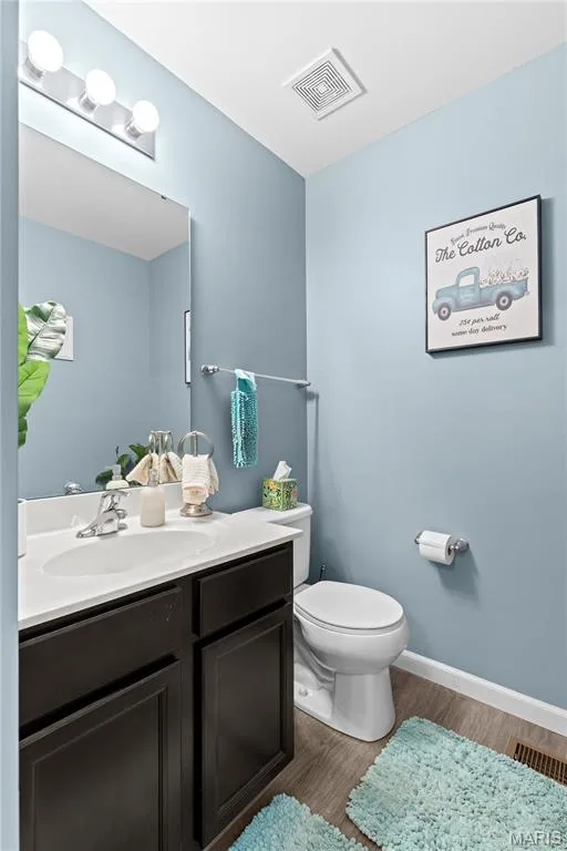 Vanity with dark wood-finish cabinetry and white countertop, featuring an integrated sink, polished chrome faucet, and mirrored backsplash — 349 Shady Rock Lane, O'Fallon, MO 63368
