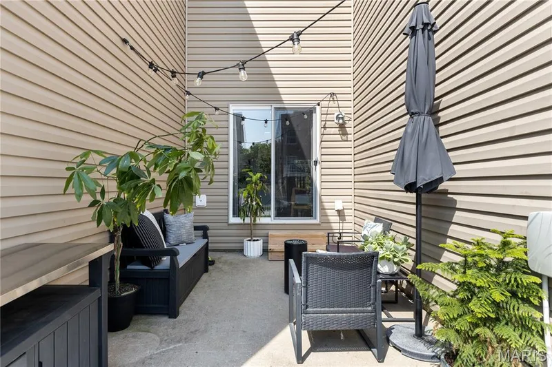Outdoor patio area featuring concrete flooring and beige horizontal siding — 349 Shady Rock Lane, O'Fallon, MO 63368