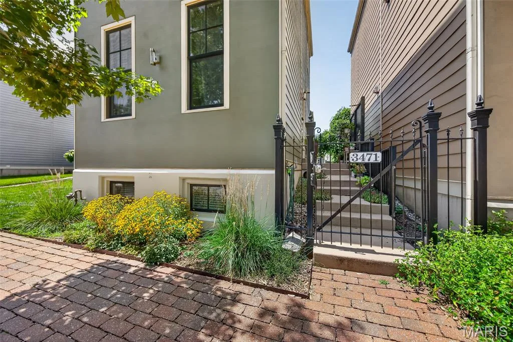 Modern two-story residence featuring a fresh exterior palette with contrasting siding, multiple window openings for natural light, and a brick-paved front walkway — 3471 Hiram Street, St Charles, MO 63301