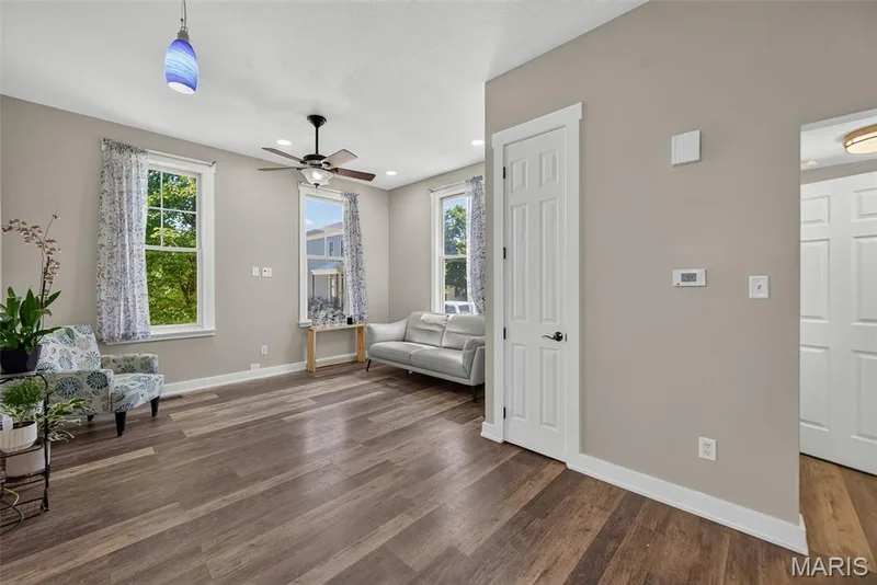Bright and spacious living area showcasing hardwood flooring, neutral wall finishes, and abundant natural light from multiple windows — 3471 Hiram Street, St Charles, MO 63301