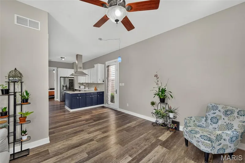 Open-concept living space with vaulted ceilings, wood-finish flooring, and a ceiling fan — 3471 Hiram Street, St Charles, MO 63301